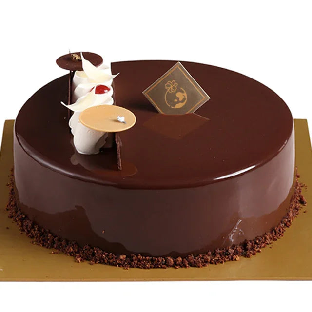 Kue cokelat mewah dengan hiasan krim putih, cocok untuk hadiah dari online florist