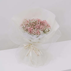 Buket bunga baby's breath pink dan putih, dibungkus kertas putih dengan pita, dari online florist terpercaya.