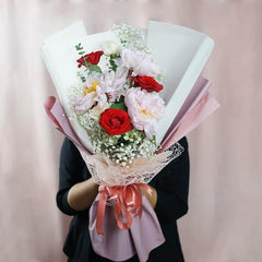 Bouquet bunga merah dan putih elegan dari online florist, dikemas rapi dengan pita pink