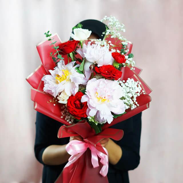 Buket bunga merah dan putih elegan dari online florist, dikemas rapi dengan pita pink, cocok untuk hadiah spesial.