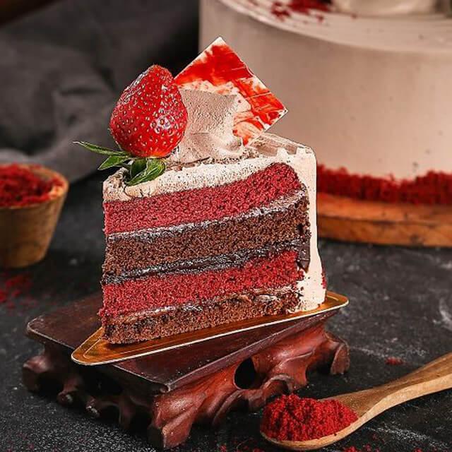 Potongan kue red velvet dengan stroberi segar, disajikan oleh online florist untuk hadiah istimewa.