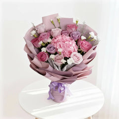 Buket bunga mawar dan hortensia warna ungu muda, dikemas elegan oleh online florist