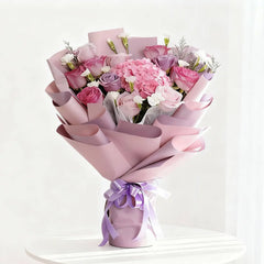 Buket bunga mawar dan hydrangea warna pink ungu, dibungkus kertas elegan, dari online florist
