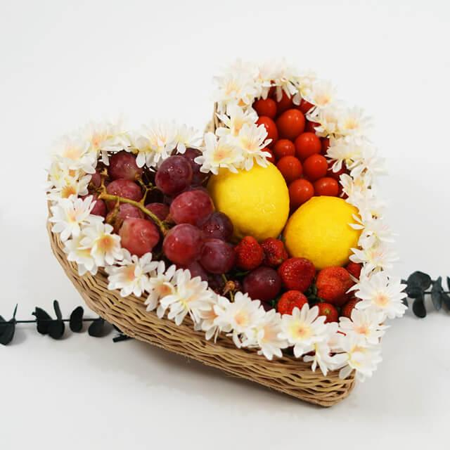 Keranjang buah hati dengan anggur, stroberi, jeruk, dan bunga putih, online florist