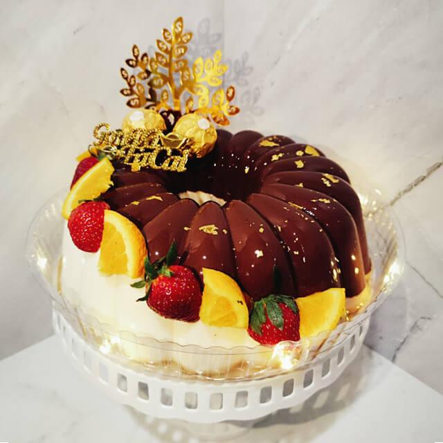 Kue cokelat dengan stroberi dan oranye, dekorasi emas, online florist