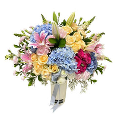 Buket bunga cantik dengan mawar kuning, hydrangea biru, dan lili pink dari online florist