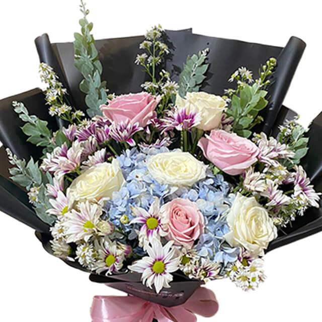 Buket bunga mawar pink dan putih dengan hydrangea biru, dikemas elegan oleh online florist