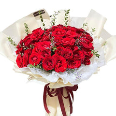 Buket bunga mawar merah segar dari online florist, dikemas elegan dengan pita merah dan kertas putih.