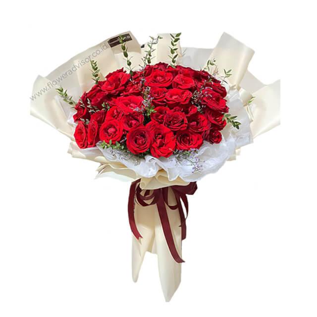 Buket bunga mawar merah segar dari online florist, dibungkus elegan dengan pita merah marun