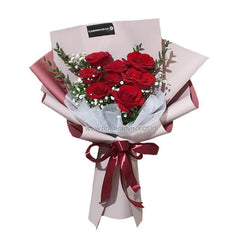 Buket bunga mawar merah elegan dari online florist, dikemas rapi dengan pita merah dan kertas pembungkus.