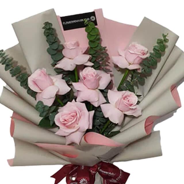 Buket bunga mawar pink segar dari online florist, dikemas elegan dengan pita merah dan kertas kraft