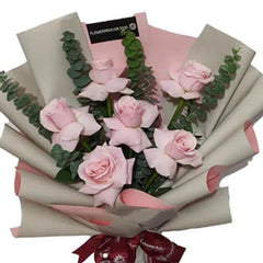 Buket bunga mawar pink segar dari online florist, dikemas elegan dengan pita merah dan kertas kraft