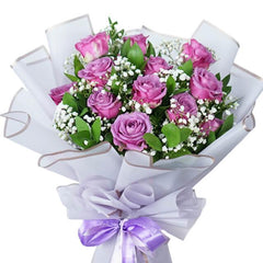 Bouquet mawar ungu elegan dari online florist, dilengkapi pita ungu dan bunga kecil putih.