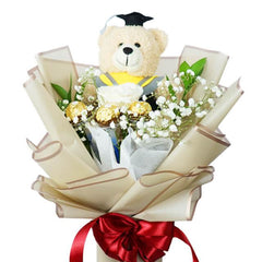 Bunga wisuda dengan boneka beruang, cokelat, dan pita merah dari online florist