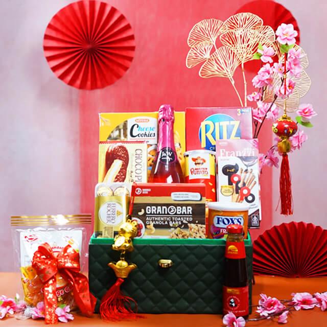 Hadiah perayaan Imlek dengan kue, cokelat, dan dekorasi merah, dari online florist