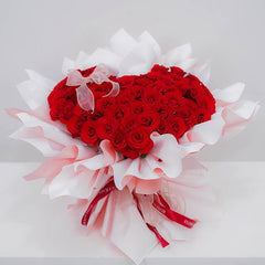 Buket bunga mawar merah berbentuk hati dari online florist, dikemas elegan dengan pita dan kertas pembungkus putih.