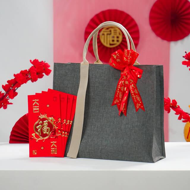Tas hadiah online florist dengan angpao merah dan hiasan Imlek, siap kirim bunga ke seluruh Indonesia
