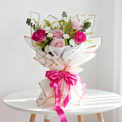 Buket bunga mawar pink dan merah muda dari online florist, dibungkus kertas putih dengan pita merah muda