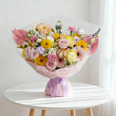 Buket bunga warna-warni dari online florist, dikemas cantik dengan pita ungu, cocok untuk hadiah istimewa.