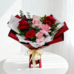 Buket bunga mawar merah dan pink dari online florist, dibungkus kertas merah dengan pita emas
