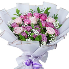 Buket bunga mawar ungu dan pink dari online florist, dibungkus kertas putih dengan pita ungu