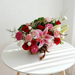 Bunga segar dalam keranjang dengan mawar merah, lili pink, dan karnasi, dari online florist