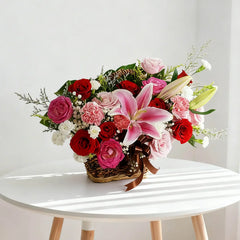 Bunga segar dalam keranjang anyaman, rangkaian mawar merah, lili pink, dan karnasi, ideal untuk hadiah dari online florist