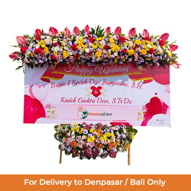Bunga pernikahan online florist untuk Denpasar/Bali, rangkaian warna-warni dengan papan ucapan Happy Wedding