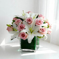 Buket bunga mawar pink dan lili putih dalam vas kaca hijau, layanan online florist untuk hadiah istimewa.