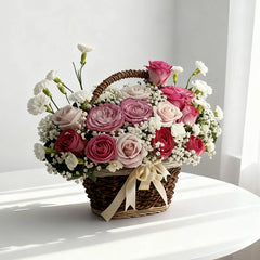 Bunga mawar merah muda dan putih dalam keranjang anyaman, disajikan oleh online florist untuk hadiah istimewa.