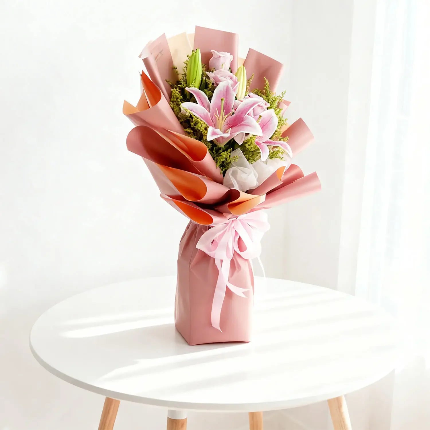 Buket bunga lili dan mawar pink elegan dari online florist, dibungkus kertas warna pastel dengan pita cantik.