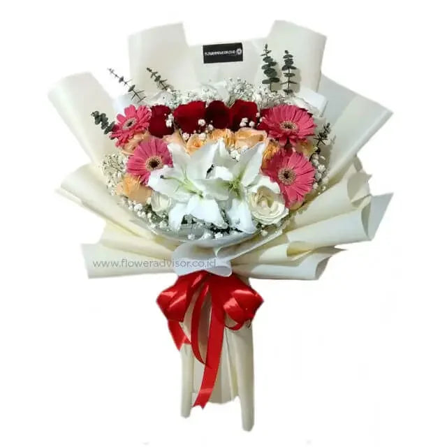 Buket bunga cantik dengan mawar merah, bunga lili putih, dan gerbera pink, dikemas rapi dengan pita merah. Online florist terpercaya.