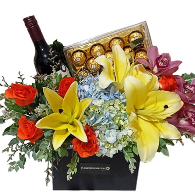Bunga segar dengan lili kuning, mawar merah, anggur, dan cokelat Ferrero Rocher dari online florist