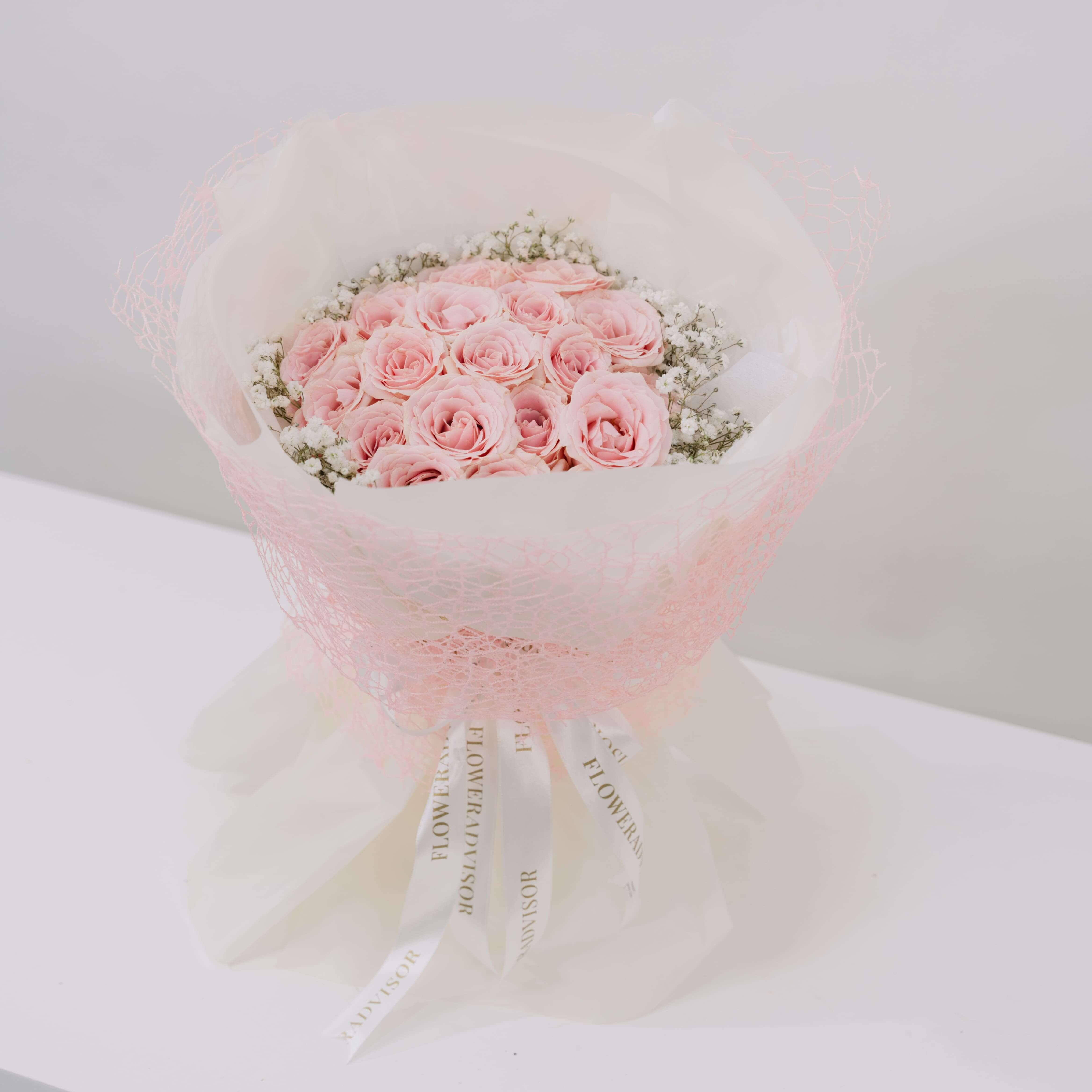Buket mawar pink cantik dari online florist, dibungkus kertas putih dan renda pink, cocok untuk hadiah.