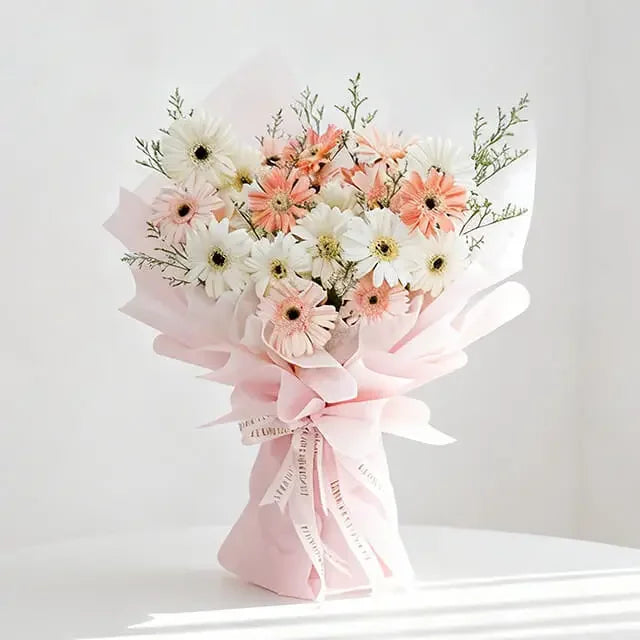 Buket bunga gerbera putih dan peach dari online florist, dibungkus kertas pink elegan