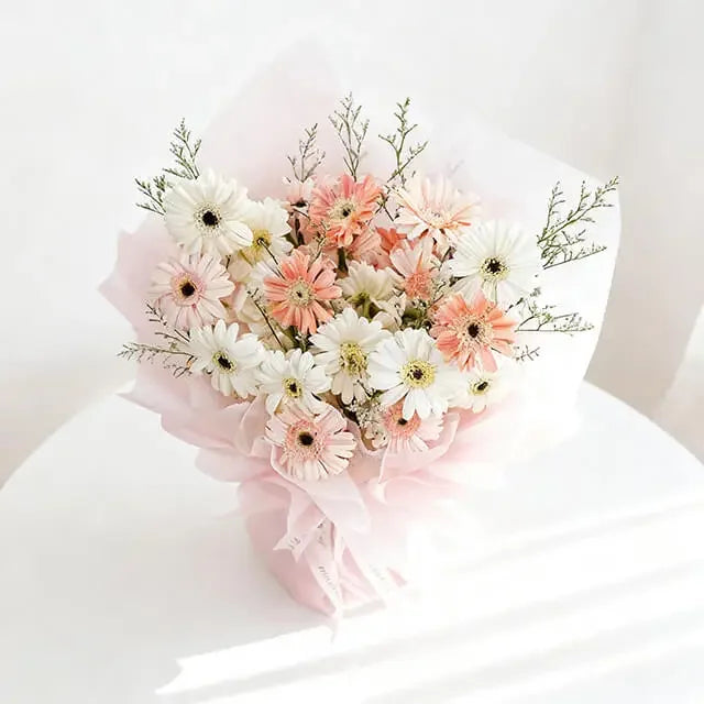 Buket bunga gerbera putih dan peach dari online florist, dibungkus kertas pink lembut