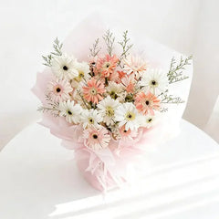 Buket bunga gerbera putih dan peach dari online florist, dibungkus kertas pink lembut