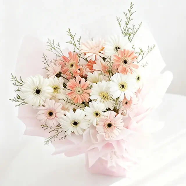 Buket bunga gerbera putih dan peach dari online florist, dibungkus kertas pink lembut
