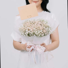 Bouquet bunga baby's breath putih dan pink dari online florist, dikemas rapi dengan pita dan kartu ucapan.