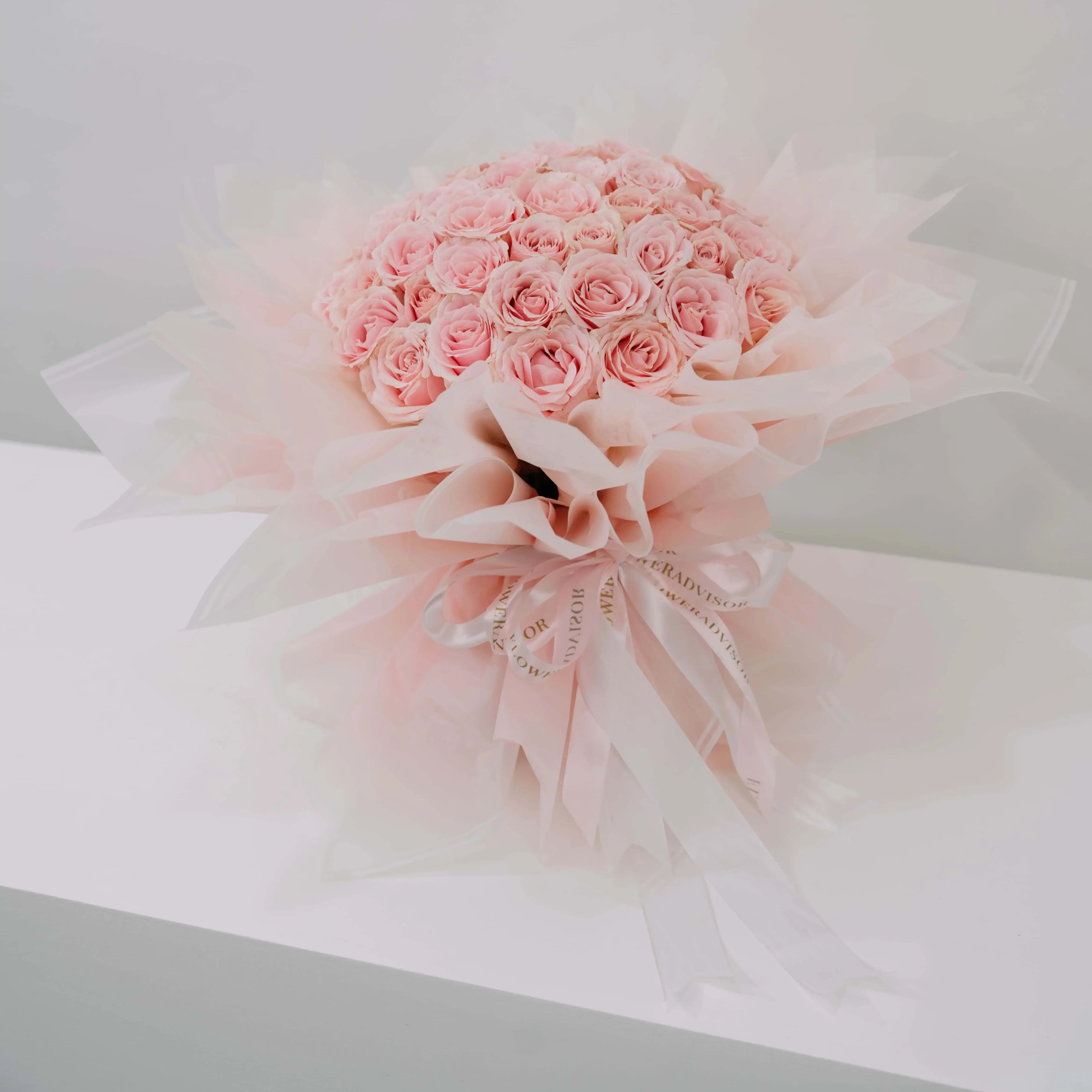 Bouquet mawar pink cantik dari online florist, dikemas elegan dengan pita dan kertas transparan.