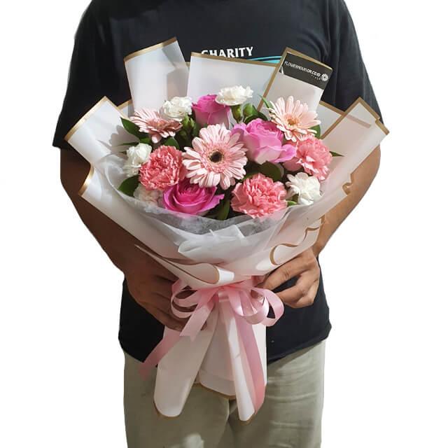 Buket bunga mawar dan gerbera pink, dikemas elegan dengan pita, dari online florist terpercaya