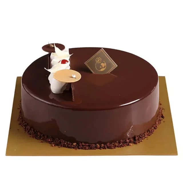 Kue cokelat mewah dengan hiasan krim putih, ideal dari online florist untuk hadiah spesial.