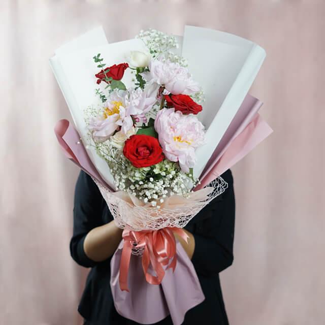 Bouquet bunga merah dan putih elegan dari online florist, dikemas rapi dengan pita pink