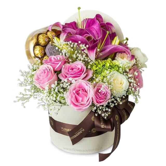 Bunga mawar pink dan lili ungu dalam kotak hadiah, disertai cokelat Ferrero Rocher. Online florist terpercaya.