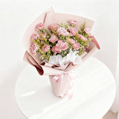 Buket bunga mawar merah muda elegan dari online florist, dikemas rapi dengan pita dan kertas pembungkus.