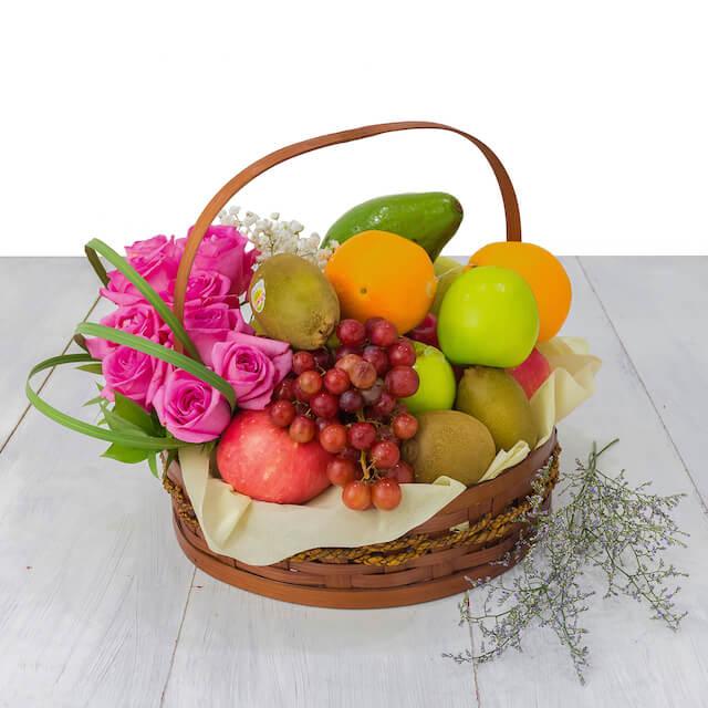 Keranjang buah segar dan bunga mawar pink, layanan online florist terpercaya untuk hadiah istimewa.
