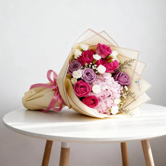Bouquet bunga mawar merah muda dan ungu dari online florist, dikemas cantik dengan pita pink