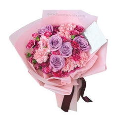 Bouquet bunga mawar ungu dan karnasi pink dari online florist, dikemas cantik dengan pita cokelat.