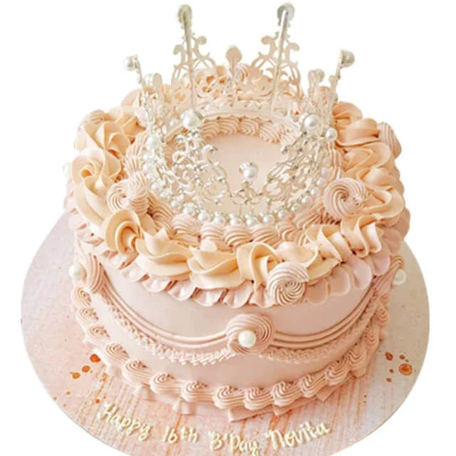 Kue ulang tahun mewah dengan mahkota perak, dekorasi krim pink, dan tulisan 'Happy 16th B'Day Novita' - online florist
