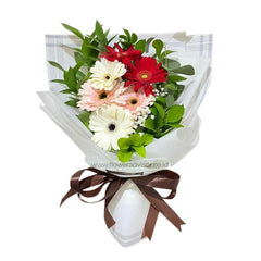 Buket bunga segar dengan gerbera merah, putih, dan pink, dikemas rapi. Online florist terpercaya untuk pengiriman bunga.